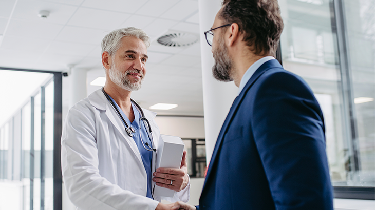 médico e colaborador de mãos dadas 