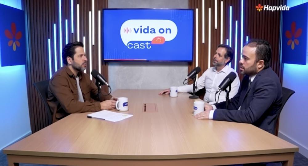 Três pessoas conversando na mesa do podcast