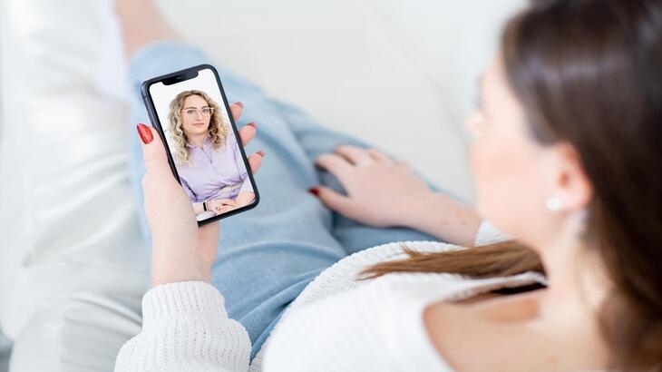 mulher utilizando telefone em teleconsulta