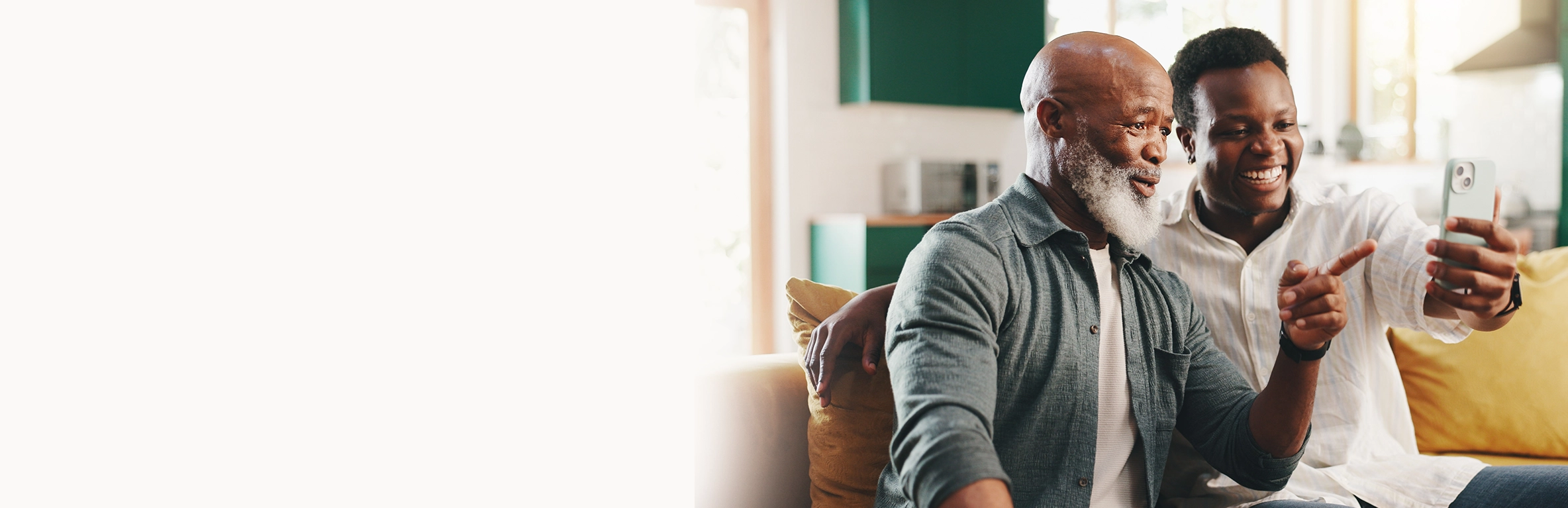 Dois homens sorrindo, olhando para o celular.