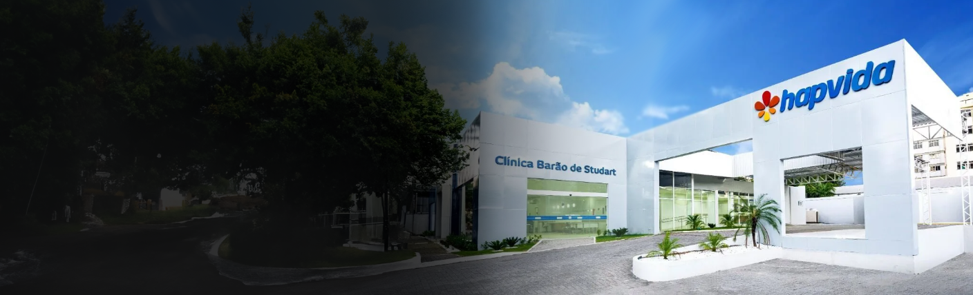 Fachada da Hapvida, com design moderno, paredes brancas, janelas de vidro e vegetação ao redor da entrada. O logotipo da Hapvida está visível no topo direito do prédio, sob um céu azul claro