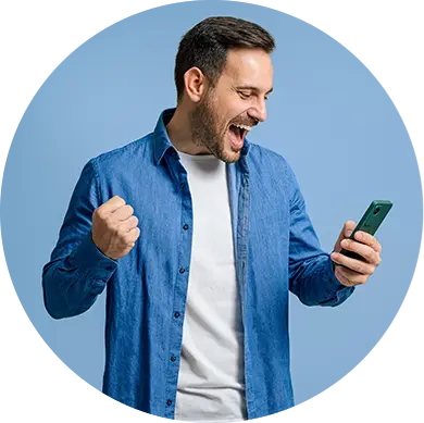 Homem com camisa azul segura smartphone com expressão de entusiasmo, punho cerrado e boca aberta, sobre fundo azul sólido. Imagem representa engajamento digital e uso ativo de aplicativo móvel.