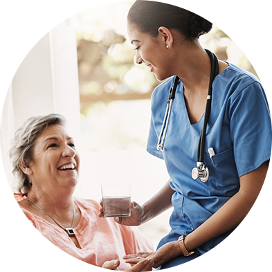 Médica com roupa azul segurando um copo de água, interagindo com a senhora sorridente, em contexto de cuidado e acolhimento.